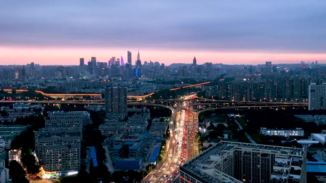 傍晚时分南京内环东线双桥门立交桥的车流和南京城市天际线航拍风光视频下载