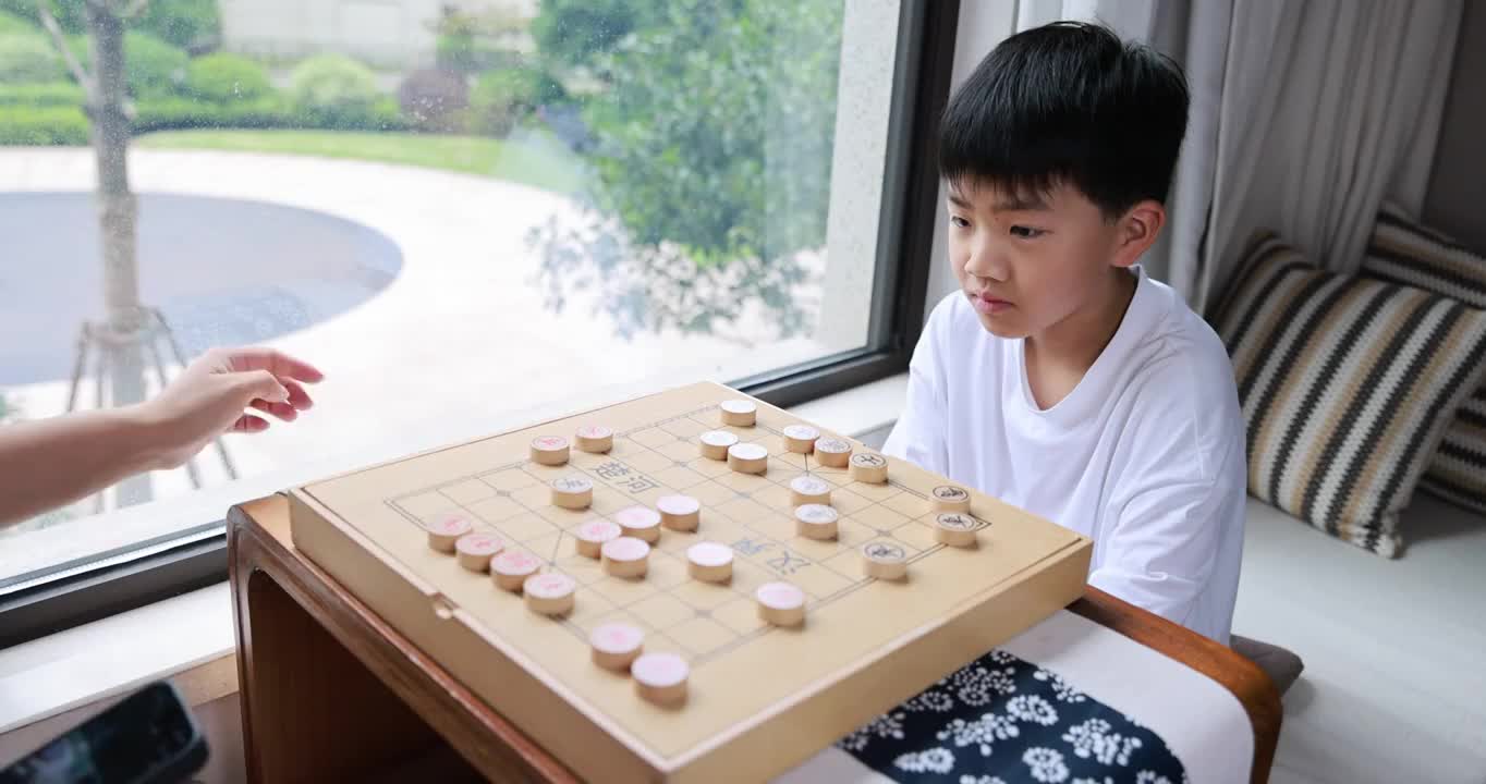 可爱的男孩在窗边下中国象棋视频下载