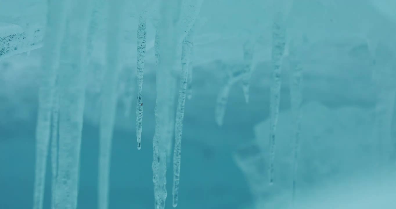冰柱滴下水滴，蓝色的冰，纯净透明，冰融化的过程视频素材