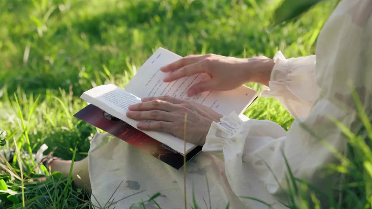 草地上的女孩看书翻书视频素材