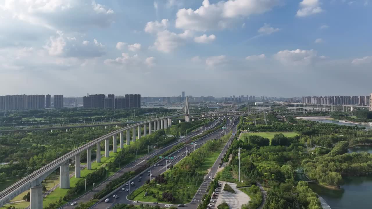 河南省郑州市高铁列车与城市天际线夏季航拍视频下载