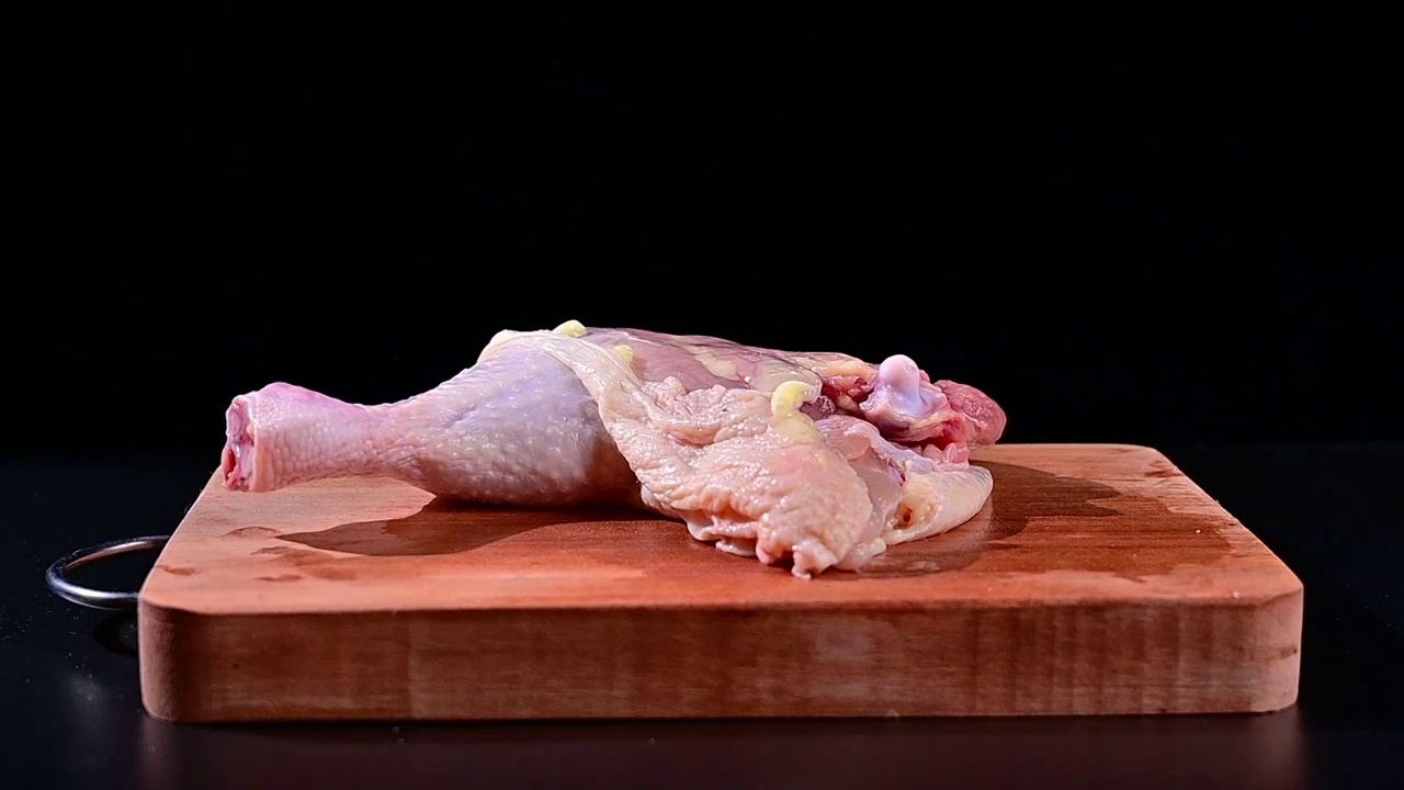 从空中掉落在砧板上的生鲜鸡大腿肉慢镜头视频下载