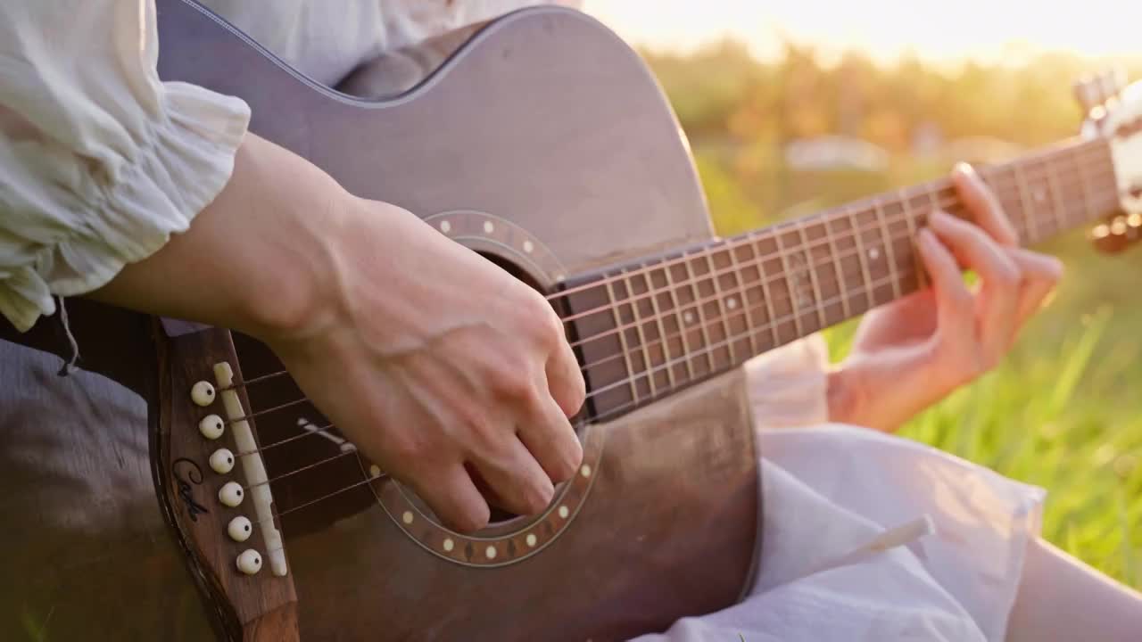 草地上弹吉他的女孩视频素材