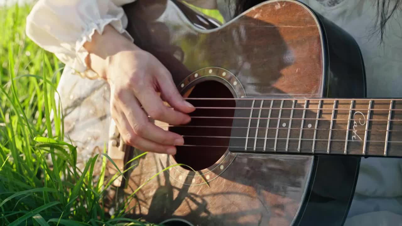 草地上弹吉他的女孩视频素材
