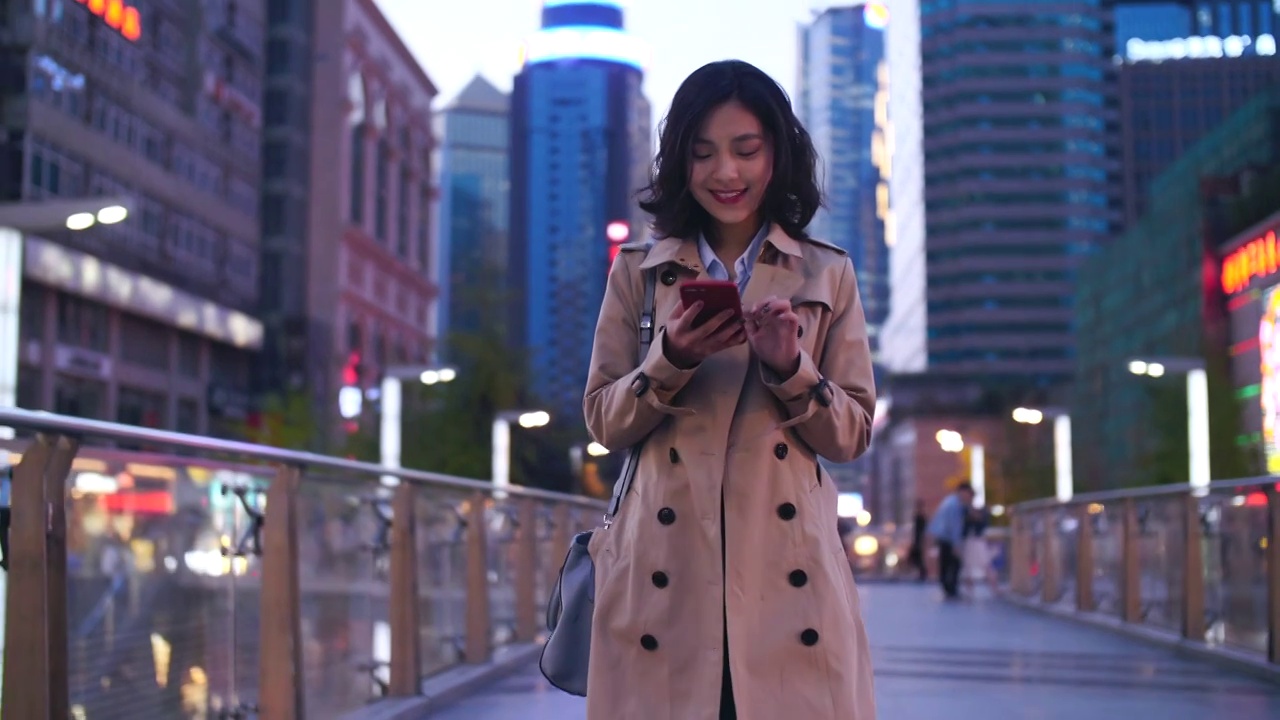 年轻美女走在成都街头看手机开心逛街视频素材