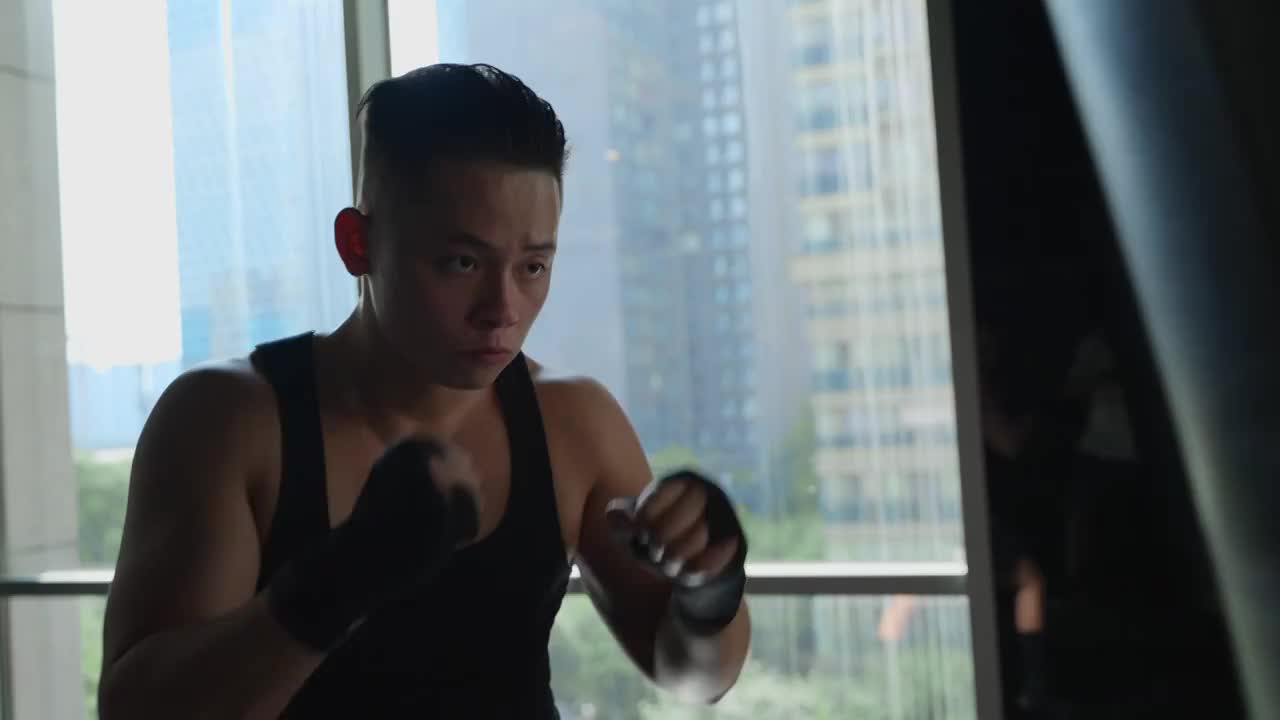 年轻男人在健身房锻炼身体练习拳击视频下载