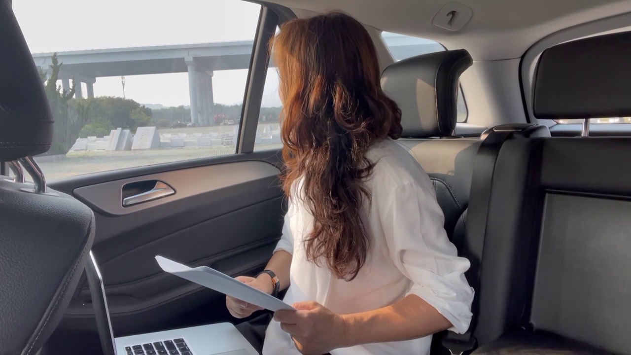 一个在车内办公的亚洲女人看向车外视频下载