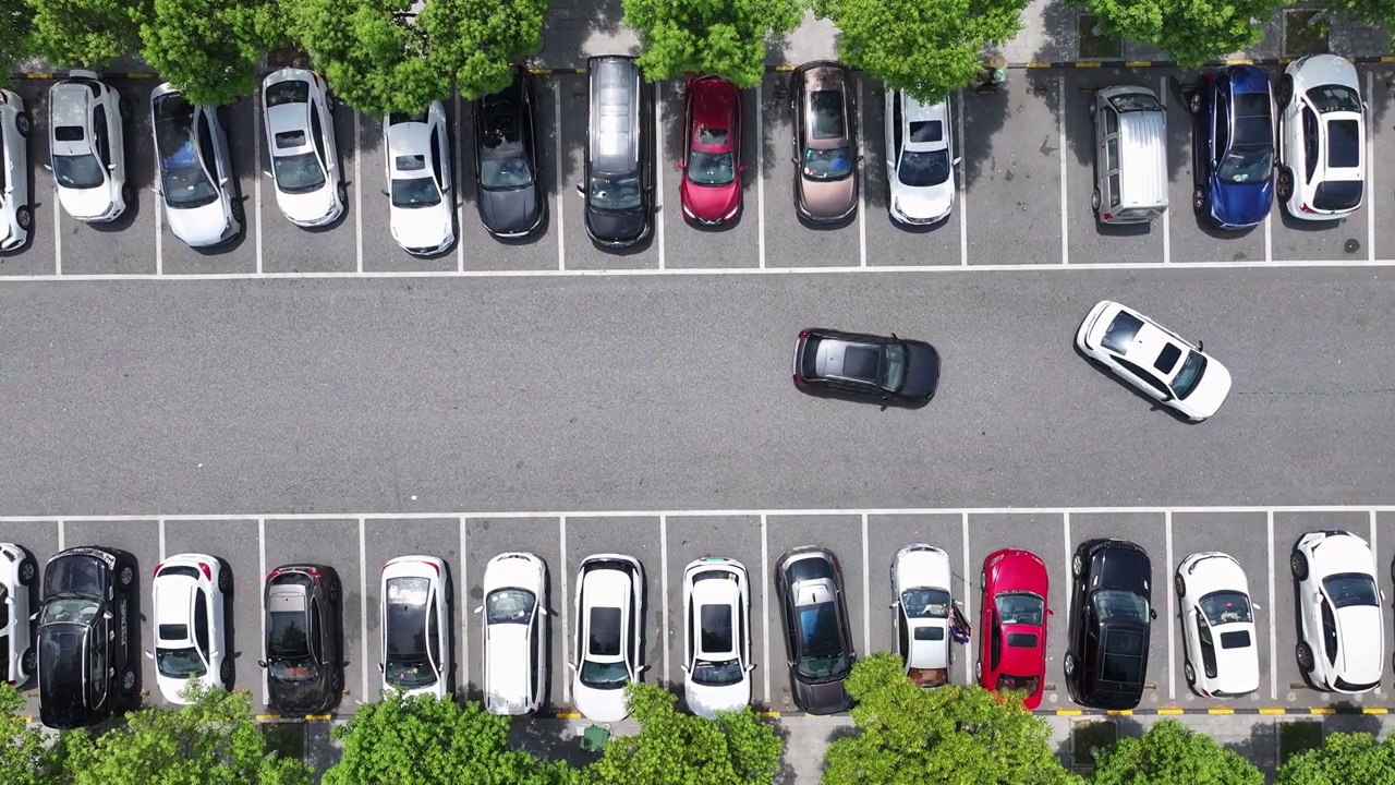 俯拍高速公路上服务区内的停车场，车辆来来往往的停入停车位视频下载