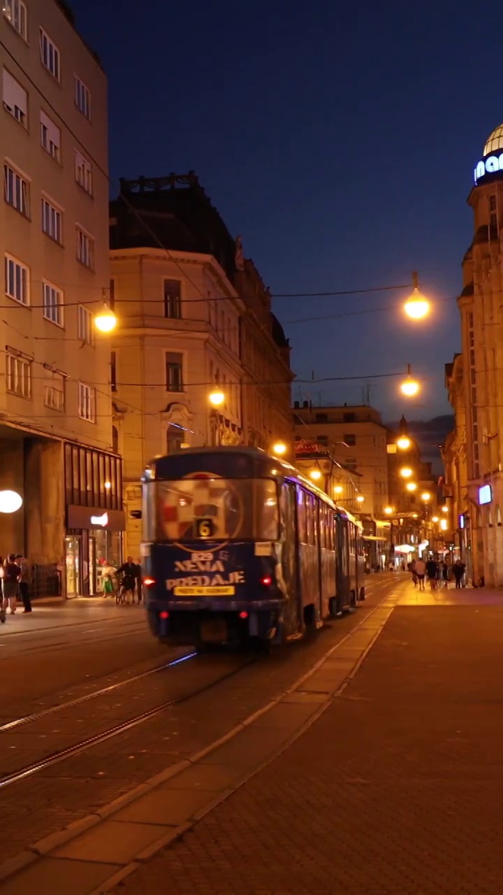 城市夜晚的电车，萨格勒布的有轨电车，城市灯火通明的夜生活，欧洲的公共交通视频下载