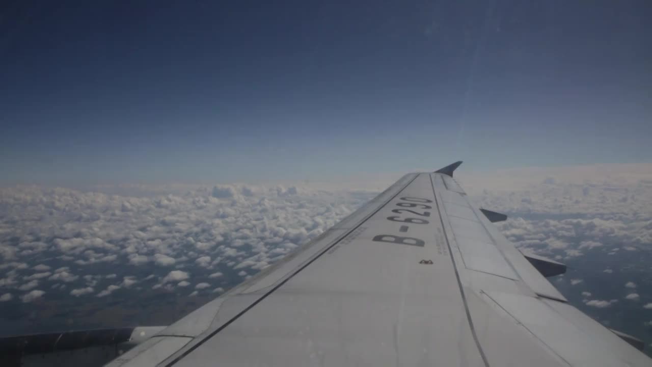 从机翼处看飞机飞在云层中视频下载
