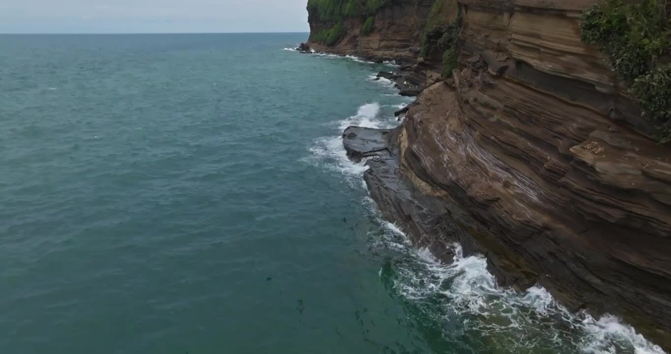 航拍涠洲岛海边悬崖峭壁浪花拍打山崖视频下载