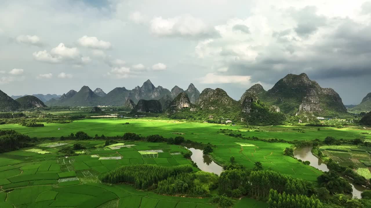 航拍桂林喀斯特山峰间的河流和绿色稻田视频素材