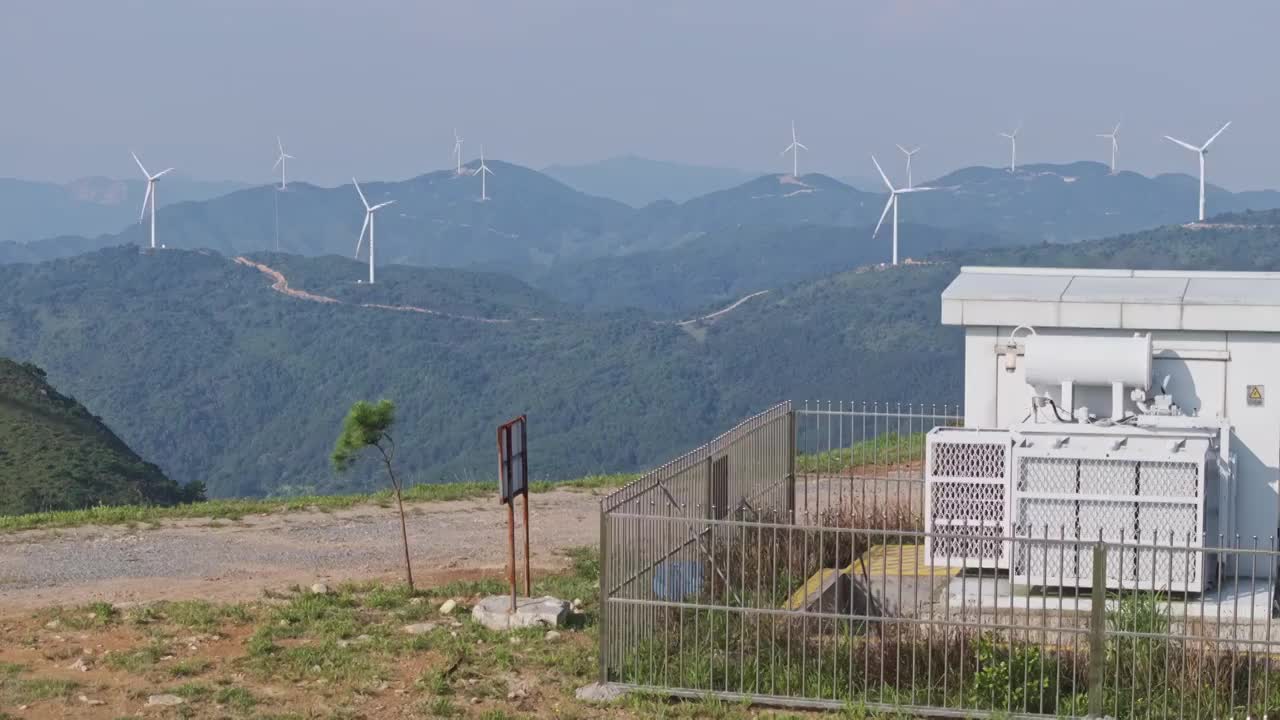山顶上的风力发电机机群和电力变压器视频下载
