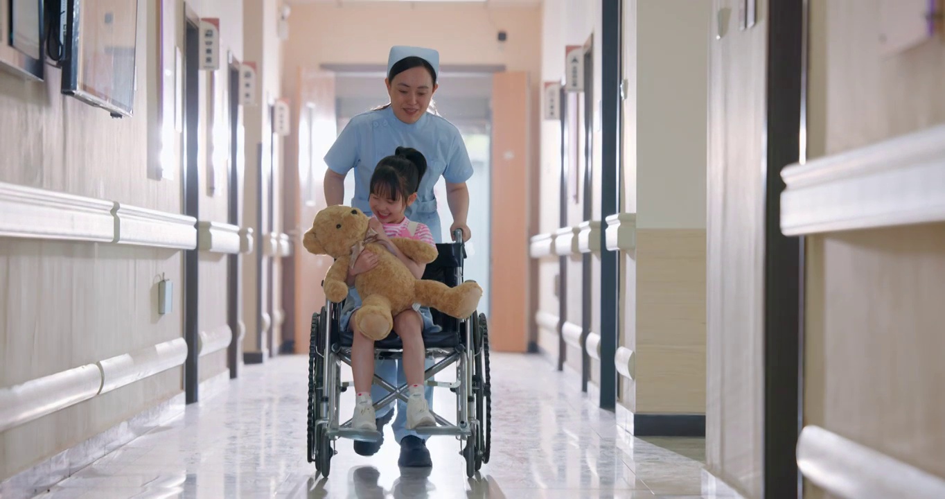 走廊内护士推着坐轮椅的小女孩视频下载