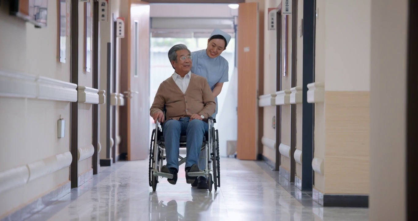 走廊内护士推坐轮椅的老人视频下载