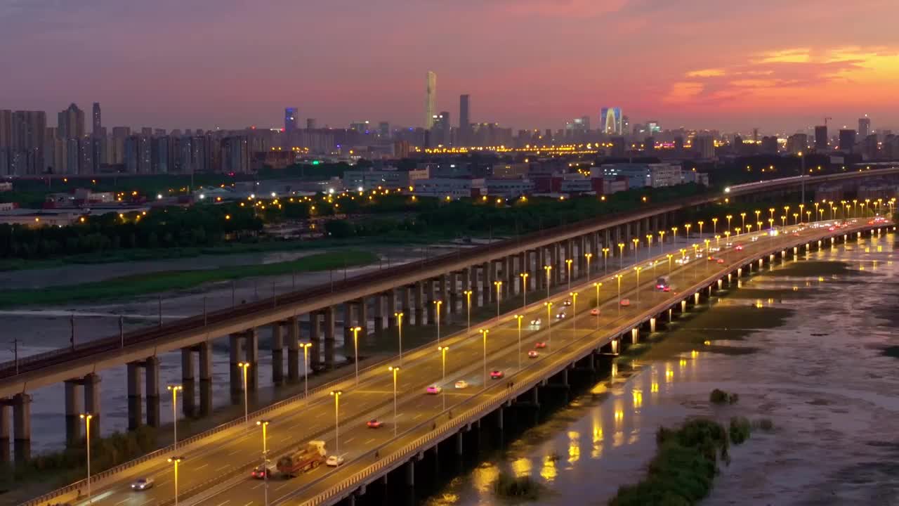 傍晚时分晚霞里的苏州阳澄湖上高铁与车流风景航拍视频下载