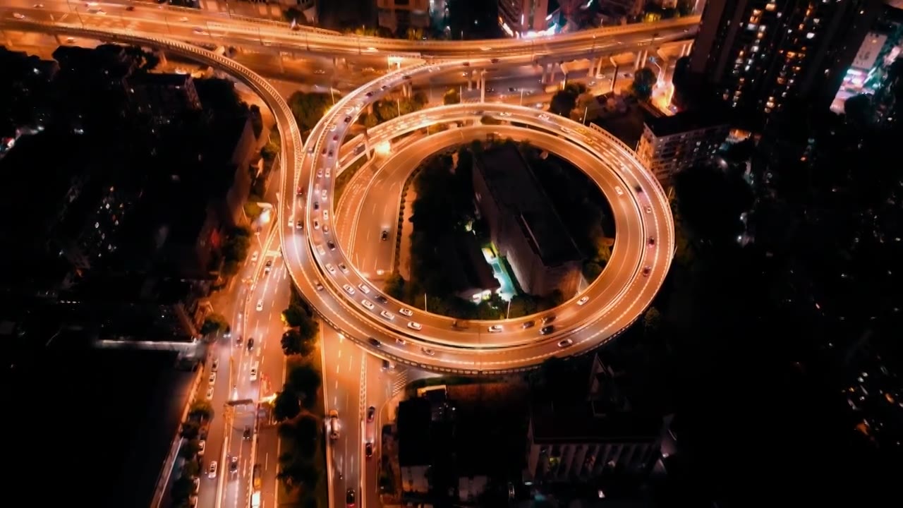 航拍城市立交桥道路匝道弯曲绵延宛如同巨龙在城市中盘旋车辆在这条光带上快速地穿梭为城市增添一份独特魅力视频素材