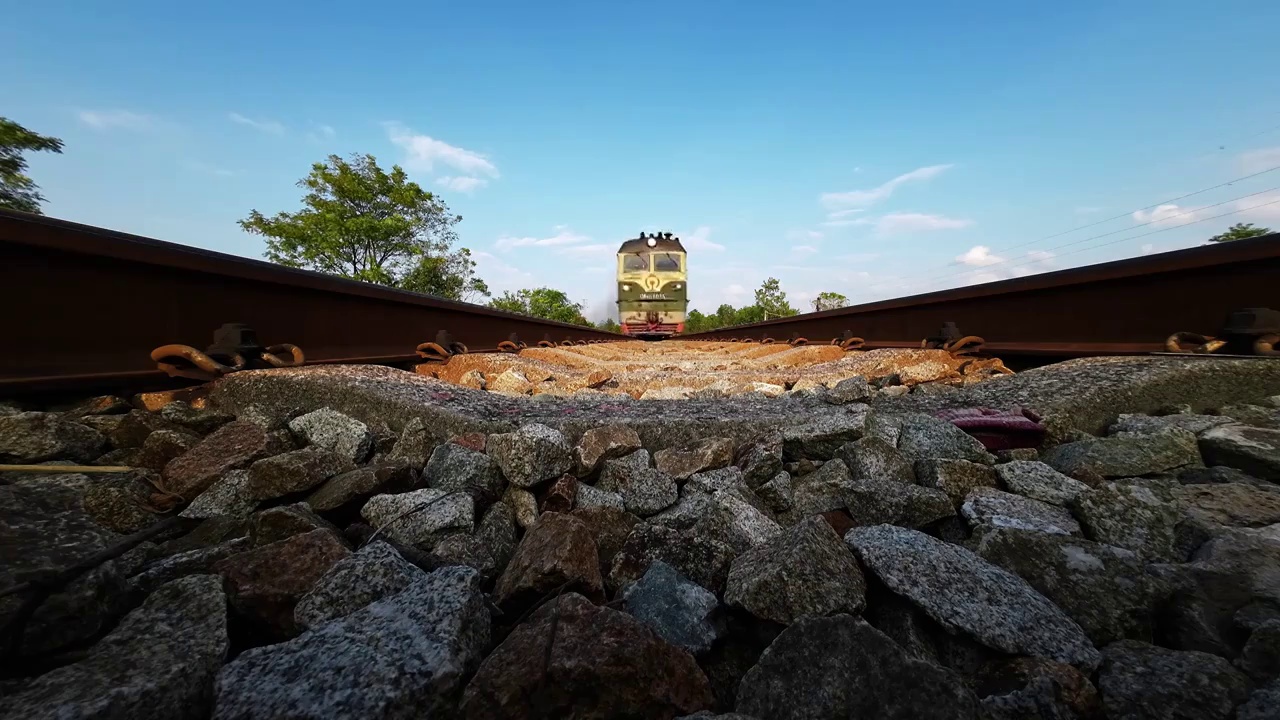 慢镜头拍摄蓝色天空下货运列车从铁轨上驶过视频下载