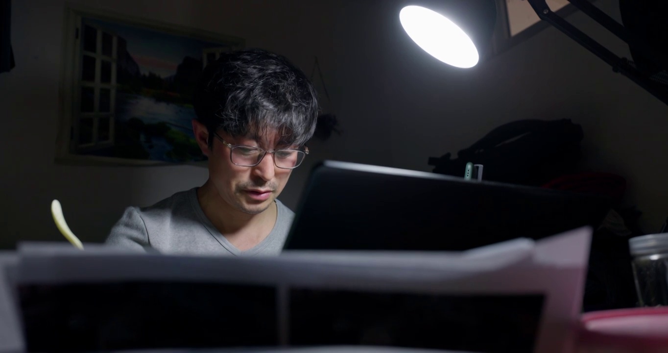 中年男人在出租房内使用笔记本电脑视频下载