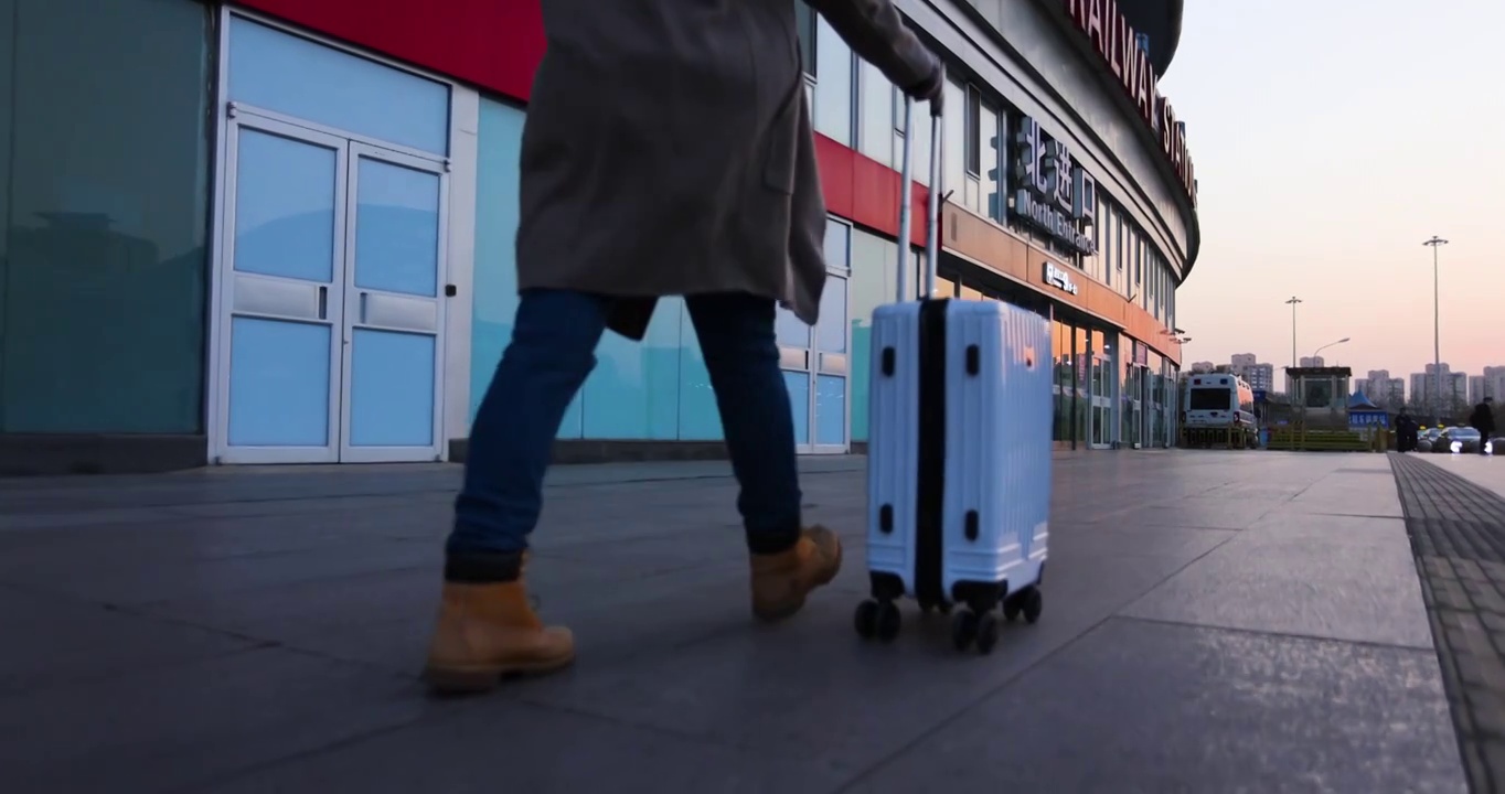一个拖着旅行箱行走的女性脚步特写,背面视角视频下载