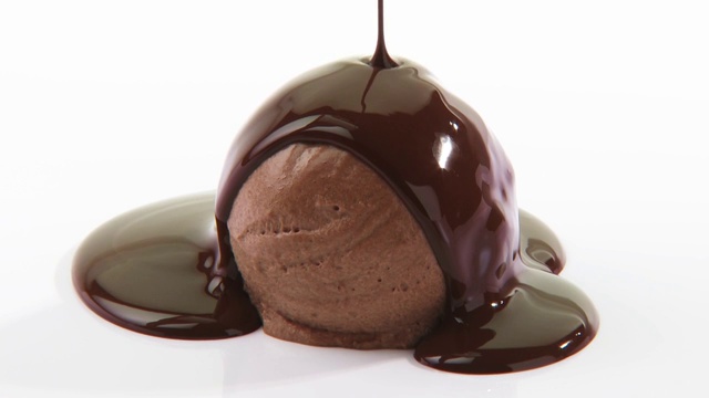 将巧克力酱浇在一勺巧克力冰淇淋上视频下载