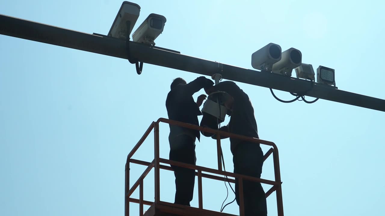 技术人员在登高台上修理安装交通监控设施视频下载