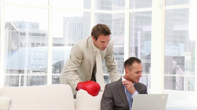 男人戴着拳击手套打同事特写视频下载