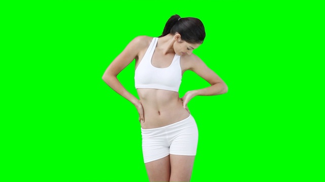 一个女人在绿色的背景下跳舞，展示她的身材视频下载