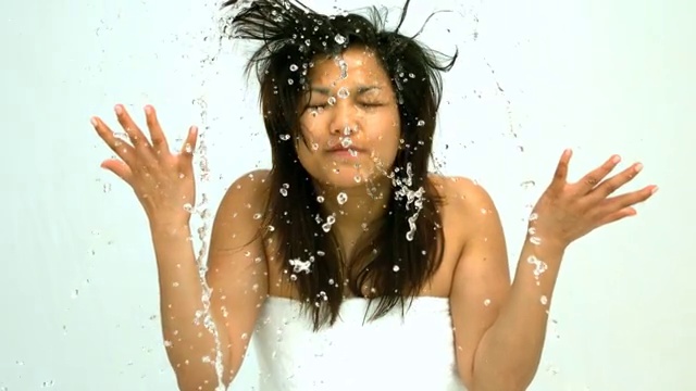 在慢镜头中，一个女人往脸上泼水视频下载