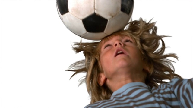 一个外国男孩头顶足球慢动作，在白色背景下视频素材