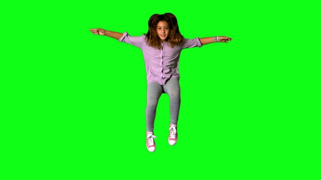快乐的小女孩在绿色屏幕上跳上跳下的慢动作视频下载