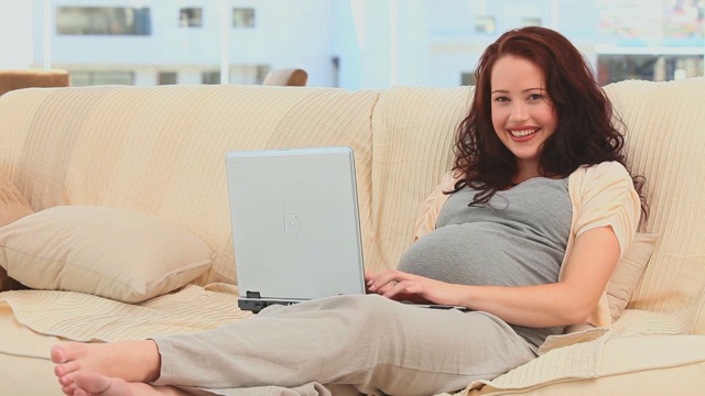 一个孕妇在客厅用笔记本电脑聊天视频下载
