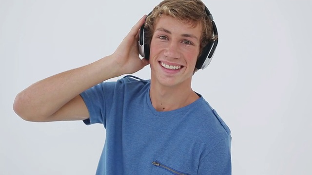 一个在白色背景下听音乐的快乐年轻人视频下载