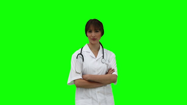 医生在绿色背景下交叉双臂走进来视频下载