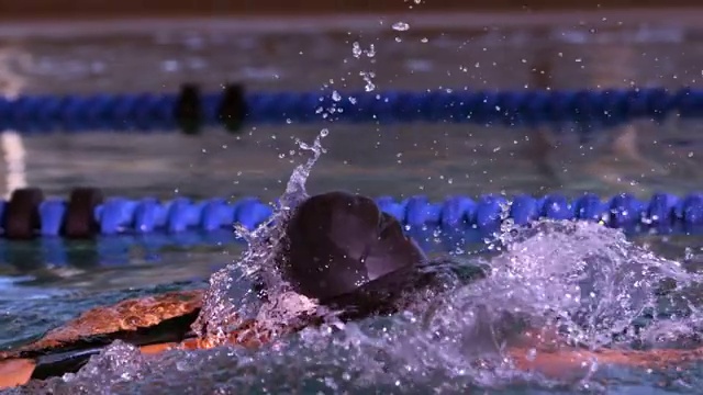 健康的游泳运动员在游泳池里用慢动作向前划水视频下载