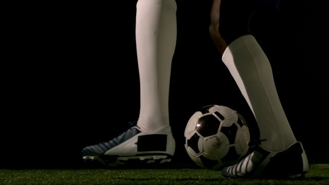 足球运动员在草地上以慢动作控制球视频下载