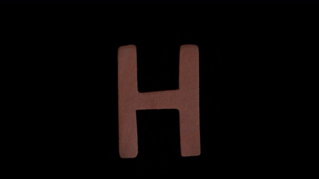 字母h在慢镜头中在黑色背景上上升视频素材