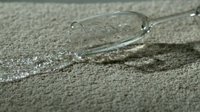 慢镜头中，一杯水洒在地毯上视频素材