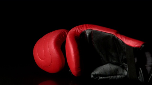在慢镜头中，红色拳击手套落在黑色背景上视频下载
