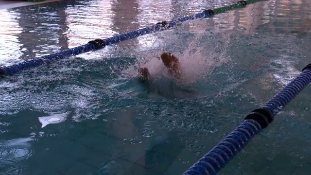 健康的游泳运动员以慢动作跳入游泳池视频素材