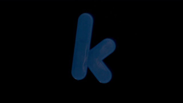 字母k在黑色背景上以慢动作进入焦点视频素材