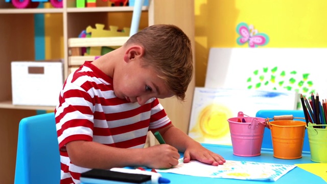 可爱的小男孩在游戏学校教室里涂色视频素材