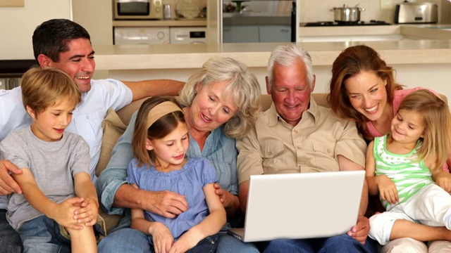 一大家族在客厅的沙发上一起使用笔记本电脑视频下载