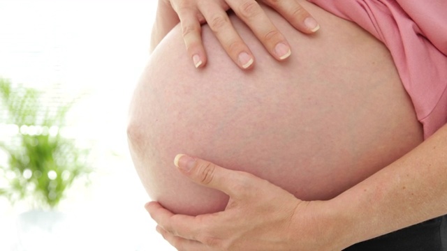 一名孕妇在医院办公室摸着自己的肚子视频素材