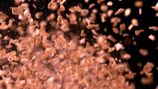 燕麦片在黑色背景的慢镜头中反弹视频素材