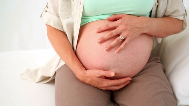 一位孕妇在医院里摸着肚子视频素材