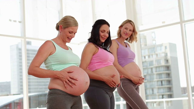 孕妇站在健身房里揉着她们的肿块视频素材