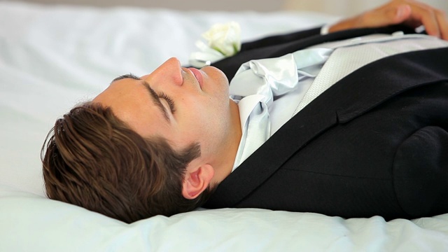 新郎在婚礼前躺在家里的一张床上视频下载