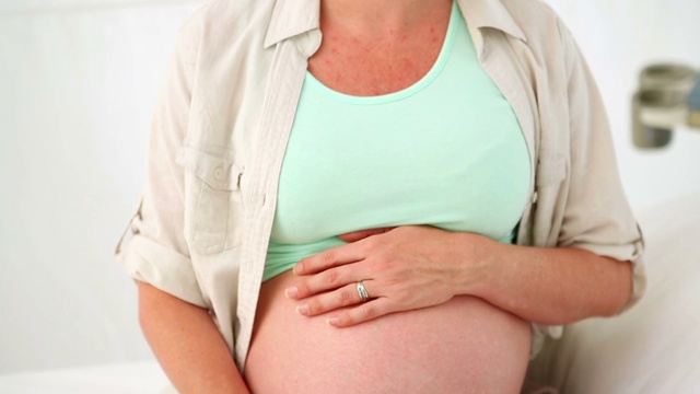 一位孕妇在医院里摸着肚子视频素材
