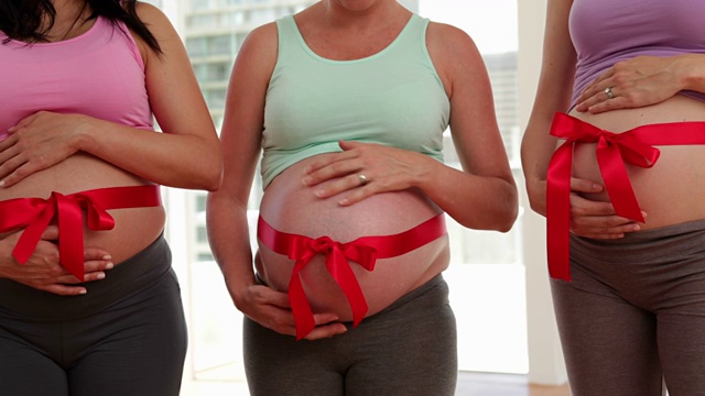 孕妇在健身房里用蝴蝶结包着肚子视频素材